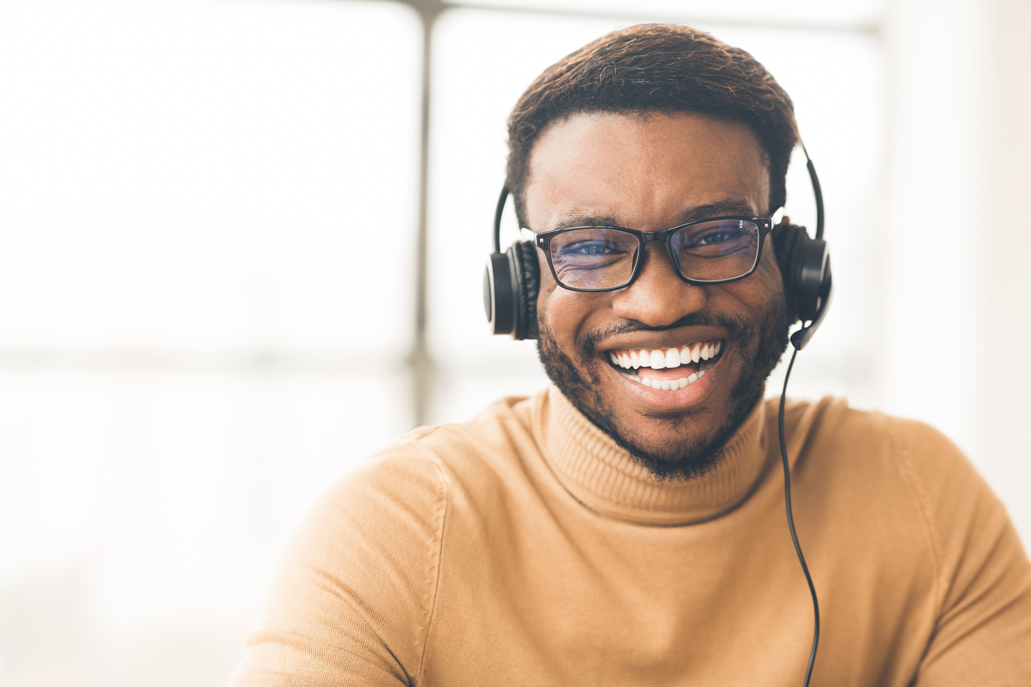 Smiling black man wearing glasses and a headset