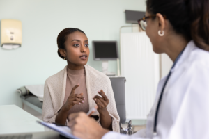 somali woman in a white coat talking to a doctor